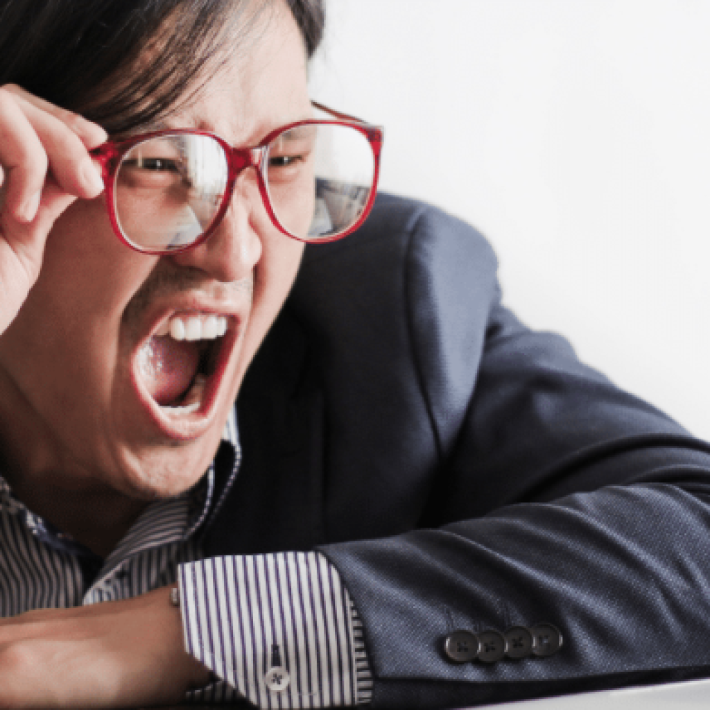 A man who has made a mistake is shouting at a laptop
