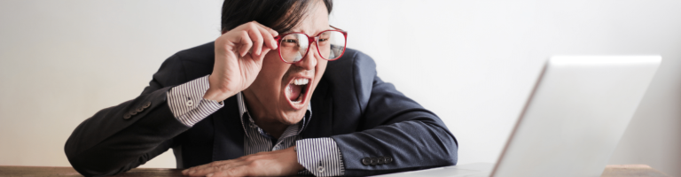 A man who has made a mistake is shouting at a laptop