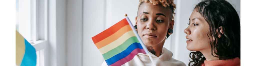 Two women holding the rainbow flag