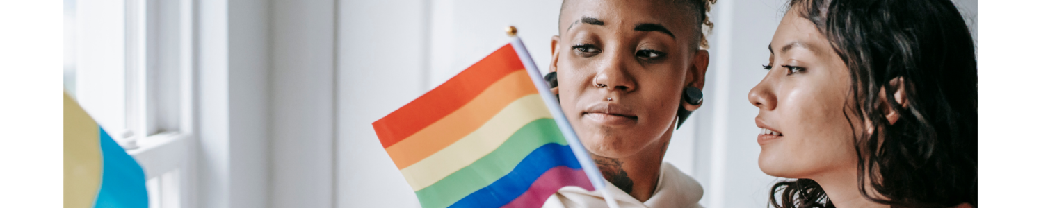 Two women holding the rainbow flag